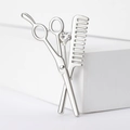 Detailed view of silver hair stylist brooch featuring scissors, comb, and a sparkling zircon - Silver