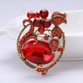 Elegante spilla vintage dorata con gemma rossa ovale e dettagli in strass floreali - Rosso