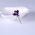 Elegante broche de rosa en esmalte púrpura oscuro y tallo dorado en un plato blanco - Morado
