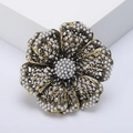 Vintage hollow flower brooch with pearl embellishments and antique metal finish on white stand - Gold