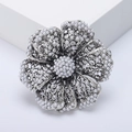 Detailed macro of vintage silver hollow flower brooch with white pearls for women - Silver