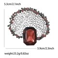 Detailed close-up of retro silver alloy brooch with red gem and rhinestone accents - Purple