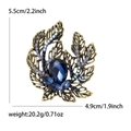 Elegant vintage hollow gold flower brooch with blue gemstone and crystal accents - Blue
