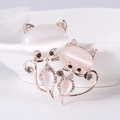 Detail van katvormige broche in roségoud met witte opaalstenen en kleine kristallen - Goud