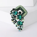 Broche vintage en cristal vert foncé et strass colorés sur un support géométrique blanc - Vert
