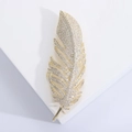 Detalle macro de elegante broche de pluma dorada con pavé de circonitas cúbicas brillantes - Dorado