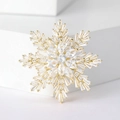 Elegant gold snowflake brooch with marquise and baguette zircons on a white pedestal - Gold