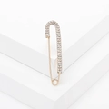 Elegant gold safety pin brooch with sparkling white rhinestones on white platform - Gold