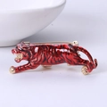 Detailed close-up of a running tiger brooch with red enamel finish and gold metal safety pin - Red