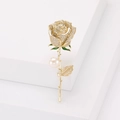 Detalle del broche de rosa con circonitas blancas, esmalte verde y perla en tallo dorado - Dorado