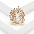 Elegant gold laurel branch brooch with champagne crystals and sparkling diamond bow accent - Champagne