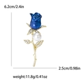 Elegante spilla a rosa blu con perla bianca e cristalli su una montatura dorata - Blu