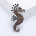 Elegant seahorse brooch with multicolored rhinestones and vintage alloy base on white background - Brown