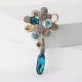 Dettaglio della spilla a fiore con diamanti grigi e gemme blu su supporto bianco - Blu-2661 / Blu
