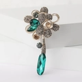 Vista dettagliata della spilla a fiore vintage con pietre smeraldo e strass grigi - Verde-2661 / Verde