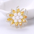 Close-up of elegant flower brooch with white pearls and gold-plated zircon petals - Yellow