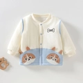 Detailopname van gebreid babyvest met schattig hondenborduurwerk en blauwe knopen - 73 / Blauw