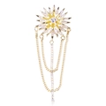 Detail der Sonnenblumen-Brosche mit goldenen Fransen und funkelnden Zirkonia-Quasten auf Weiß - Gold