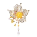 Detalle del broche de flor con gema amarilla y borlas de circón en base dorada - Amarillo