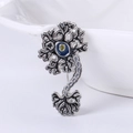Silver neuron brooch with black blue and yellow enamel pin on a white ceramic bowl - Silver
