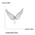 Detalle del broche de ala de ángel con perlas y dimensiones de 5,2 cm por 4,6 cm - Plateado