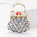 Broche luxueuse en forme de sac à main avec strass bleus et détails dorés - Style sac à main / Bleu