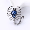 Elegante broche de escorpión plateado con un gran cristal azul oscuro en forma de gota - Azul Tinta