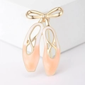Dettaglio della spilla scarpette da danza in smalto rosa con fiocco d'oro lucido - Arancione