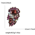 Dettaglio di una spilla vintage con gemme rosse e strass colorati su base in metallo dorato - Viola
