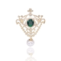 Detalle de broche vintage de corte con gema esmeralda, circón blanco y colgante de perla - Verde