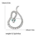 Silver snake brooch with white rhinestones and green gem eyes on a white background - Silver