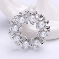 Vue détaillée de la broche couronne de fleurs argentée avec feuilles et perles blanches - Argenté