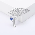 Broche arbre argentée avec oiseau en émail bleu sur fond de podium géométrique blanc - Argenté