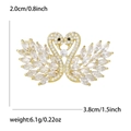 Elegant gold double swan brooch with cubic zirconia stones forming a heart shape - White