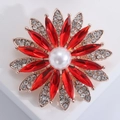 Close-up of crystal sunflower brooch with red rhinestones and a white pearl center - Red