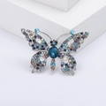 Elegante vlinderbroche met blauwe en paarse strasstenen op een zilveren metalen voet - Blauw