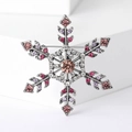 Vista dettagliata della spilla a fiocco di neve vintage con strass colorati su cubi bianchi - Rosa