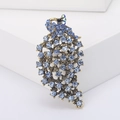 Detailweergave van de vintage pauwenbroche met blauwe kristallen op een witte stand - Blauw (MM-BR-2988)