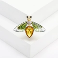 Close-up of golden honey bee brooch featuring amber crystal and iridescent wings - Green