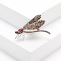 Macro-detail van een libellenbroche met kleurrijke strasstenen en rode kristallen kop - Paars