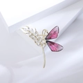 Detailed macro shot of a golden dragonfly brooch with pink wings and crystal accents - Red