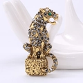 Detail der Vintage-Leopardenbrosche mit grauen und schwarzen Kristallen auf weißer Hand - Gold
