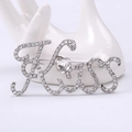 Detail der silbernen Kiss-Brosche mit funkelnden Strasssteinen und Herz-Zirkon - Silber