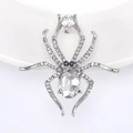 Detailed macro view of a luxury silver spider brooch with clear oval gemstone and rhinestones - Silver