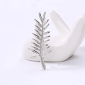 Dettaglio di spilla a foglia d'argento con trame venate su vassoio manuale in ceramica - Argento