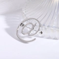Polished silver alloy @ symbol brooch pin on minimalist white fabric background - Silver