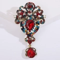 Macro de un broche vintage con diamantes de imitación de colores y colgante de gota roja - Rojo