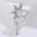 Makroaufnahme einer silbernen Blumenbrosche mit funkelnden AB-Strasssteinen und Metallkurve - Silber