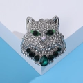 Dettaglio di spilla a testa di leopardo con strass bianchi e gemme verdi a goccia - Verde