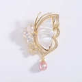 Macro-opname van een vlinderbroche met wit parelmoer en een roze parelhanger - Wit